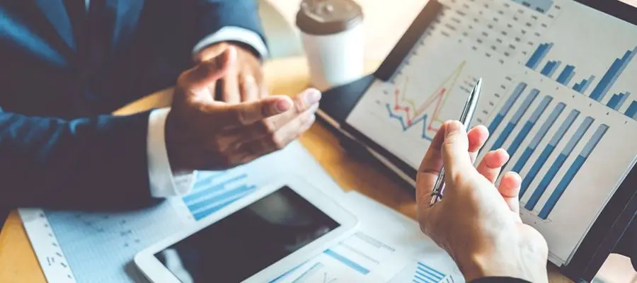 Deux hommes autour d'un écran montrant des graphiques