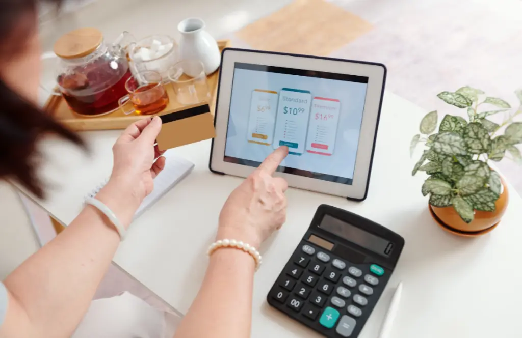 Femme avec carte bancaire, devant une tablette