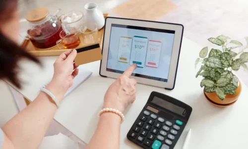 Femme avec carte bancaire, devant une tablette