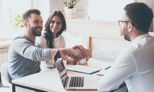 Couple heureux, l'homme sert la main à un conseiller