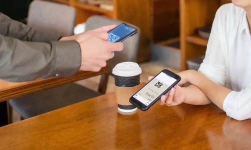 Homme et femme avec smartphone, café et qrcode